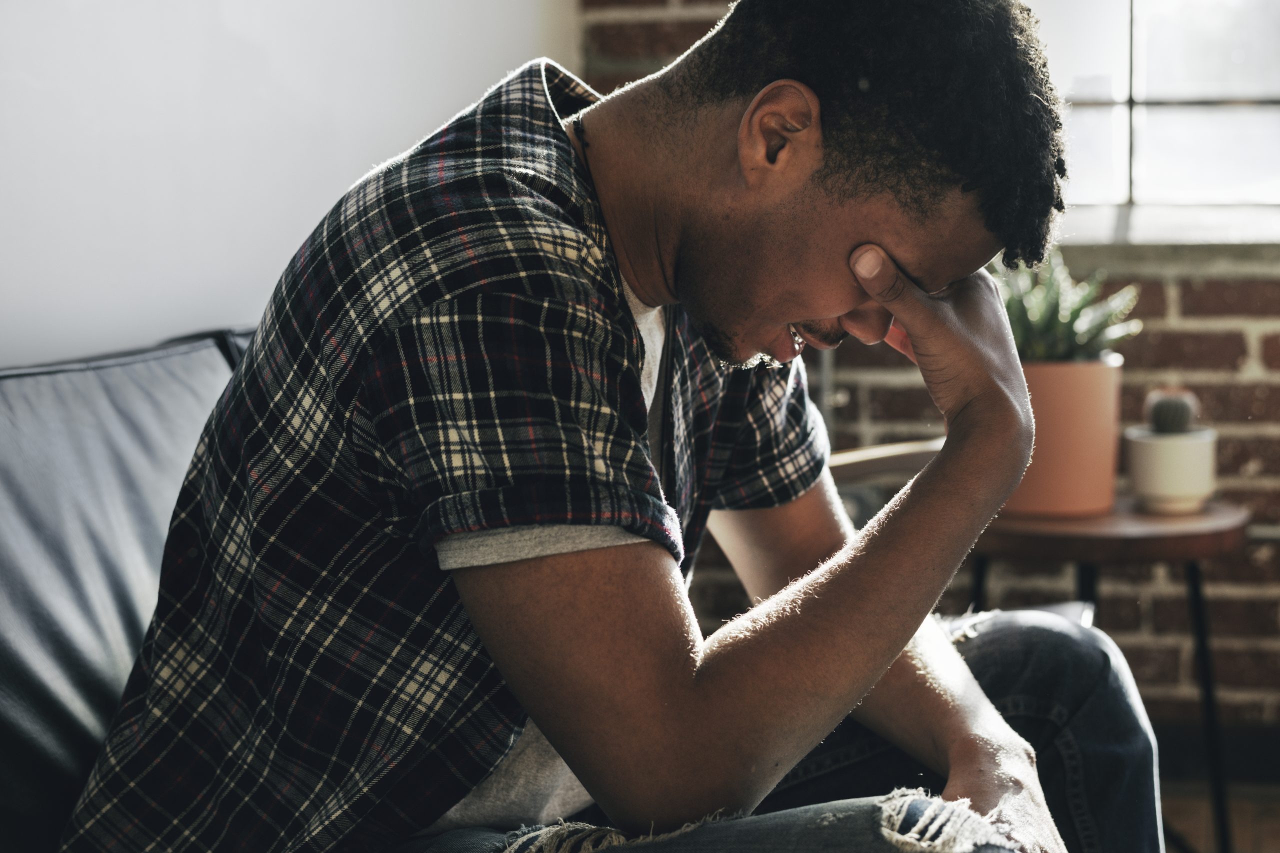 Depressed man sitting alone on a couch